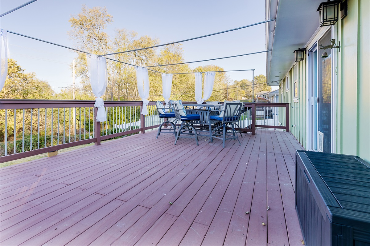 Deck with outdoor seating space, perfect for relaxing, dining, or gathering outdoors.