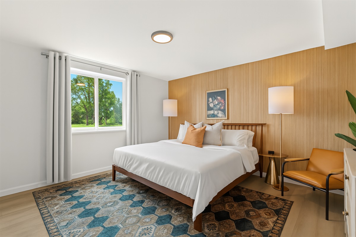 Thoughtful decor and a cozy rug elevate the comfort of this bedroom, making it the perfect place to relax after a long day.