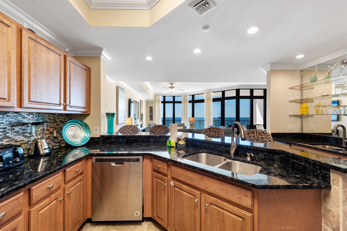 Equipped kitchen with stainless appliances, granite tops and tiled backsplash