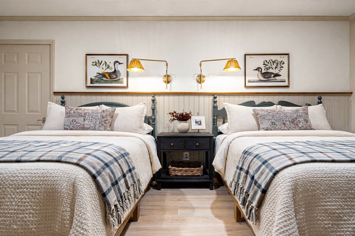 The Duck Room features two queen beds, crisp linens, and a cozy hotel-style feel—perfect for families or shared sleeping. A covered patio with seating and beautiful views is right off of the room...