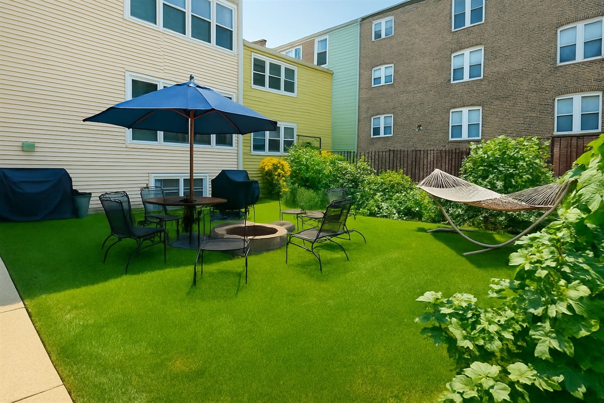 Spacious backyard patio with seating and umbrella for enjoying sunny Chicago days.