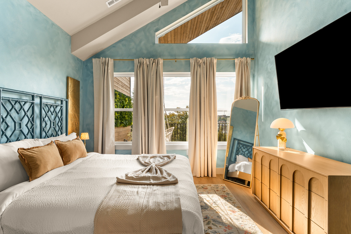 Blue King Suite – Second View
    Wake up to sunshine and beautiful views in this airy king suite, complete with vaulted ceilings, a wall-mounted TV, full-length mirror, and windows overlooking the scenery beyond.