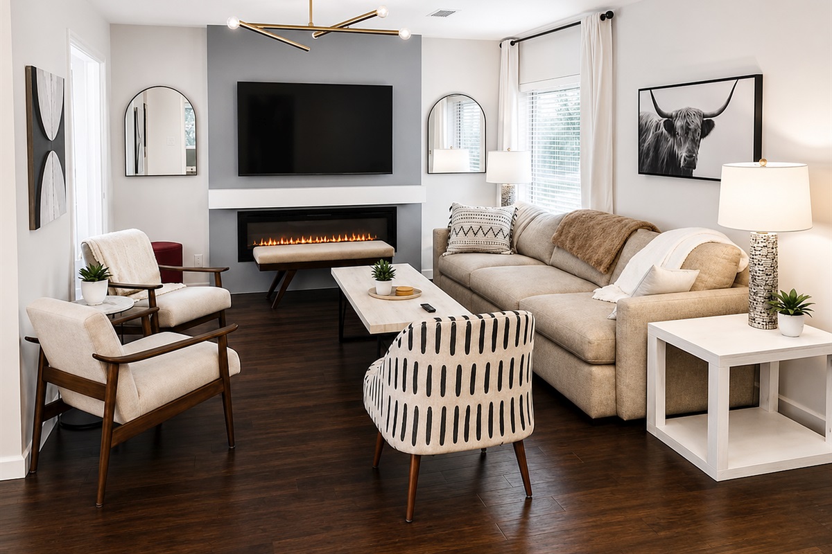 Stylish main living room with cozy fireplace, oversized smart TV, and thoughtfully curated designer furnishings