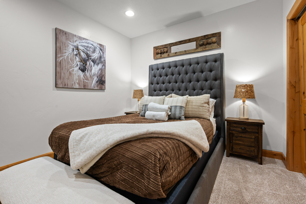 Comfortable guest bedroom with plush bedding and a warm, welcoming mountain-lodge feel.