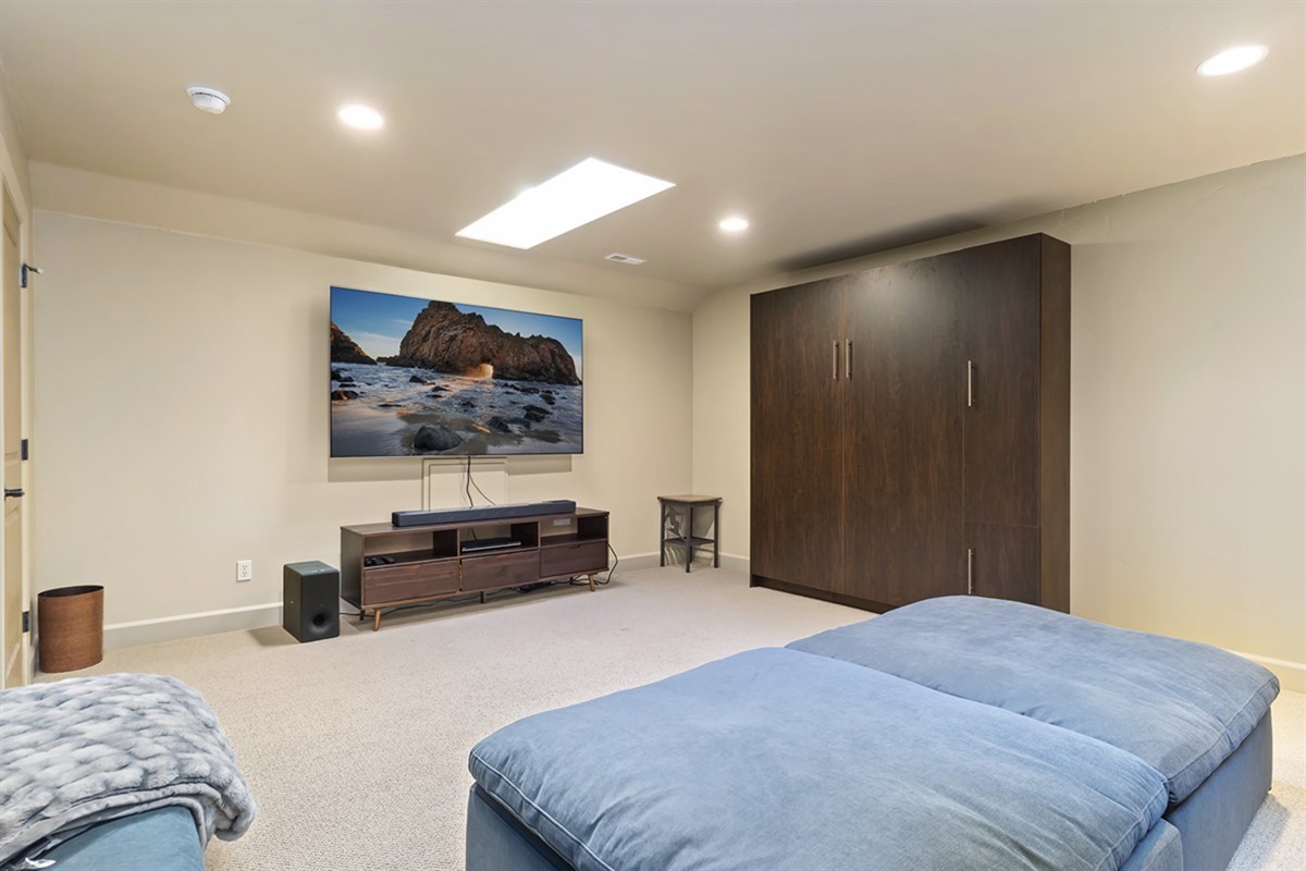 Kick back and unwind in this cozy entertainment space with a large screen and plenty of room to relax.