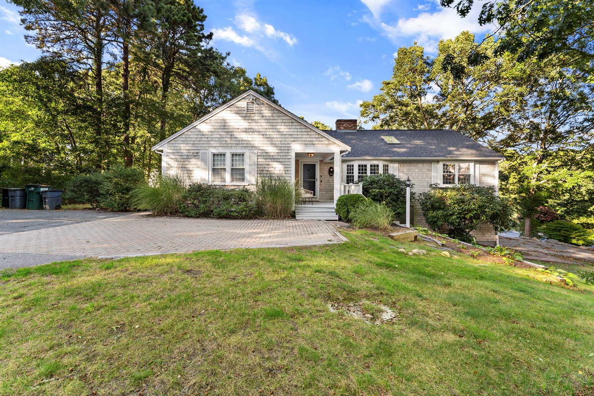 The spacious driveway provides a welcoming entrance, perfect for parking multiple cars with ease.