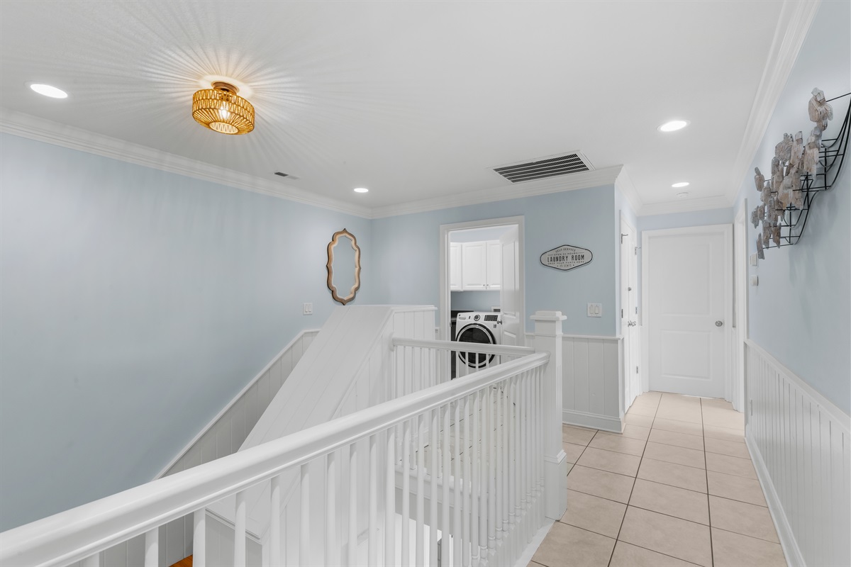 At the top of the stairs on the upper level is the laundry room
