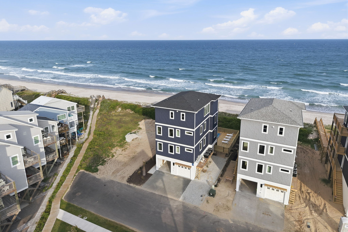 Aerial street view of Tide and Blue and surrounding homes with direct beach access and ocean views just beyond the rear of the properties