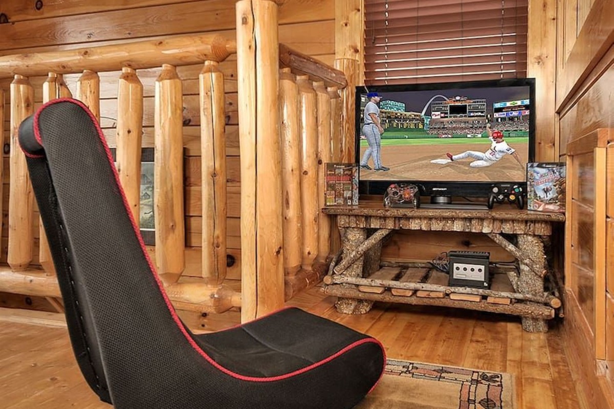 - Cozy gaming corner with flat-screen TV and rustic log railing backdrop   - Enjoy classic entertainment surrounded by the charm of mountain wood   - The perfect indoor escape for family fun and evening relaxation