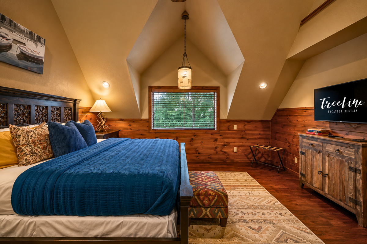 A second view shows off the spacious feel of this king retreat, where warm wood accents and comfortable furnishings keep things relaxed and inviting.