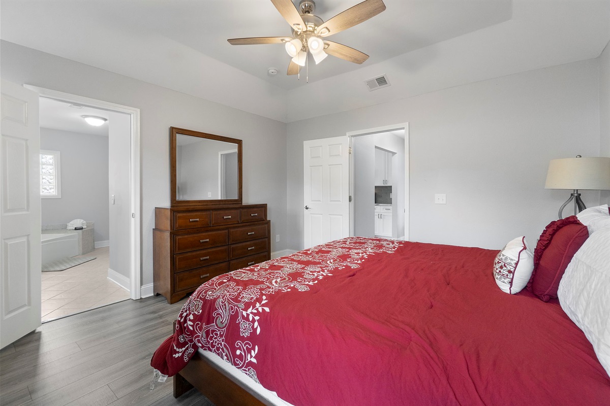 Start your mornings refreshed in this master suite that offers both style and serenity. With its vaulted ceiling, warm wood tones, and subtle beach artwork, this room is the perfect getaway after a long day of exploring.