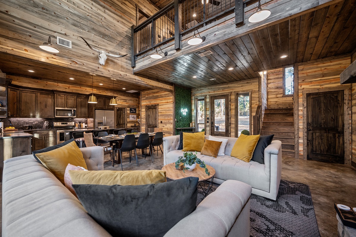Gather in the spacious living room with soaring ceilings and warm wood accents.