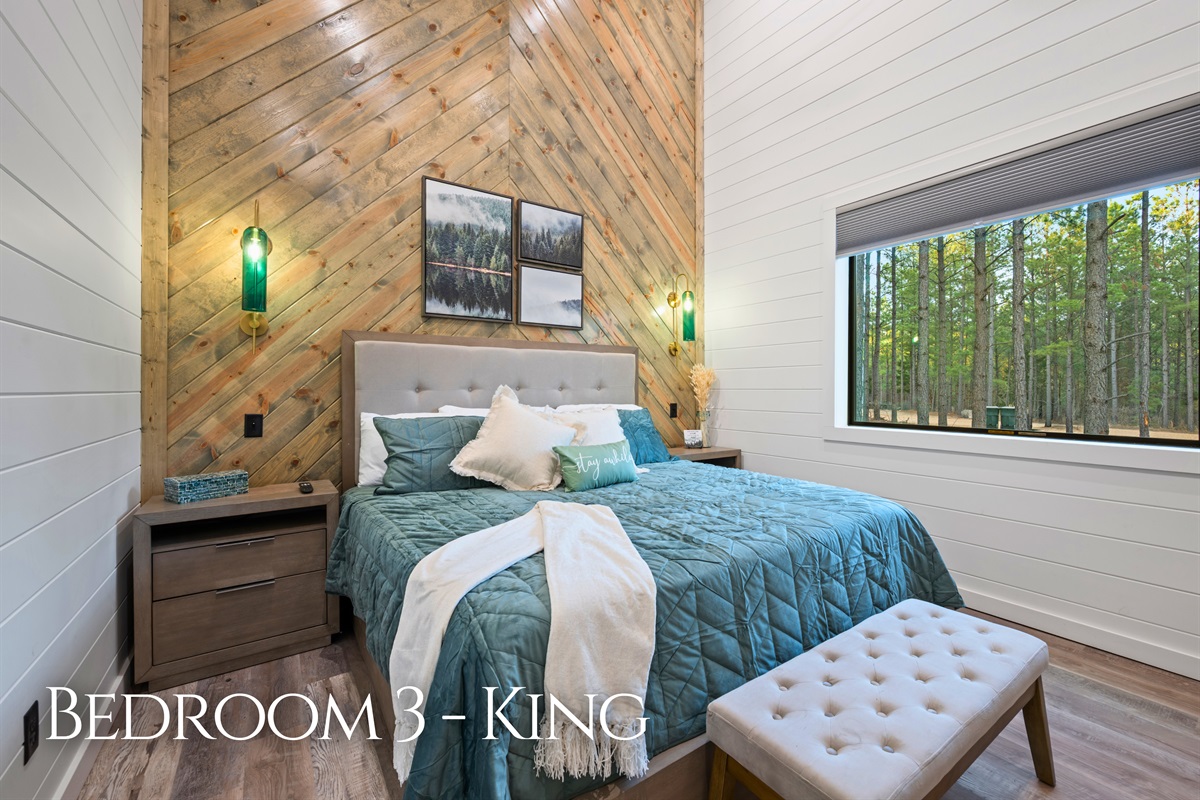 Large windows frame peaceful forest views while the comfortable king bed invites you to slow down and enjoy a quiet night of rest.
