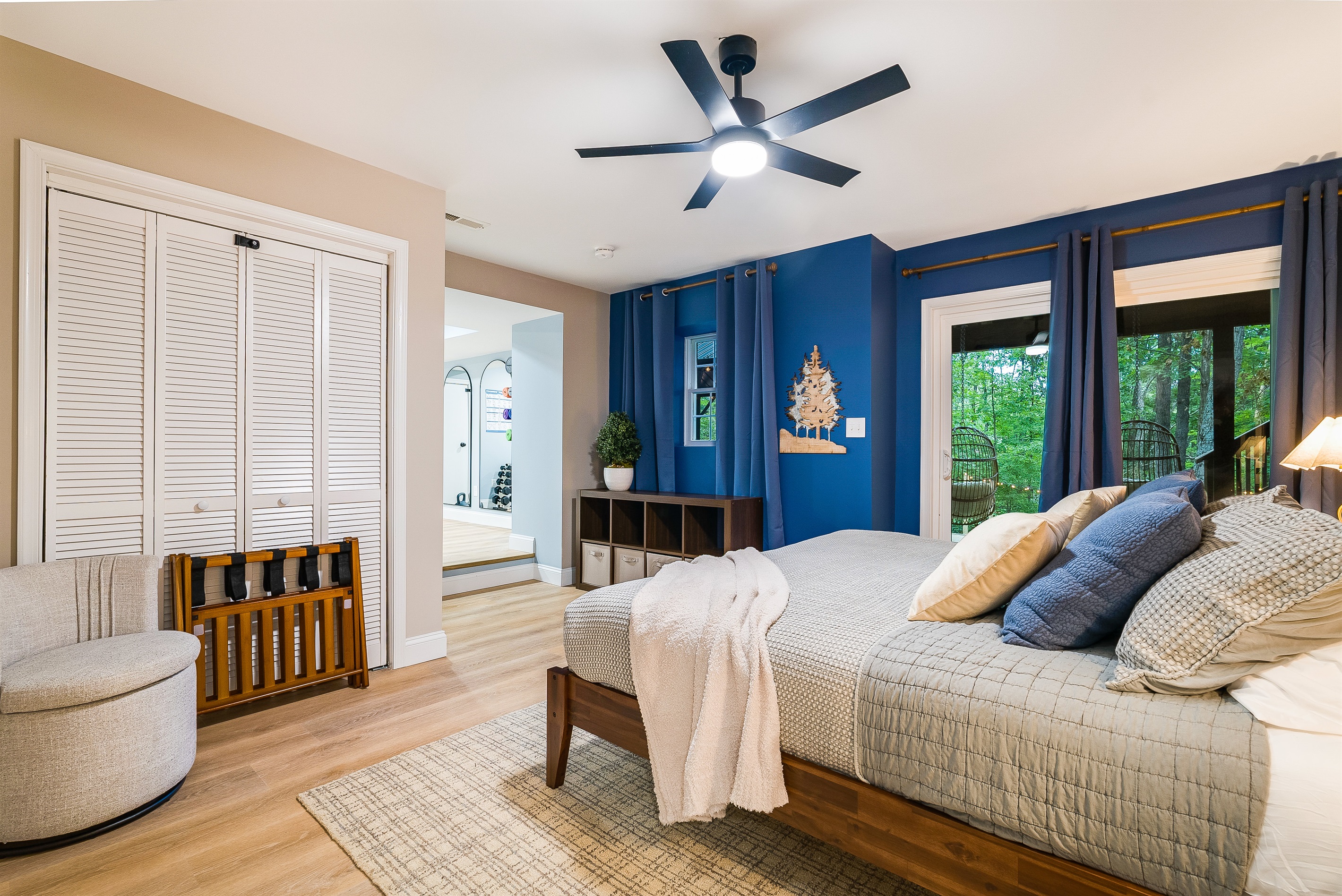 Wake up to forest views in this spacious bedroom with walkout deck access. A peaceful retreat for early risers who love morning coffee outdoors or anyone craving quiet moments away from the main gathering spaces.