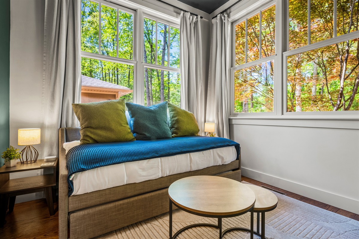 Enjoy peaceful woodland views from the corner daybed—perfect for curling up with a book, an afternoon nap, or stargazing from the comfort of bed.