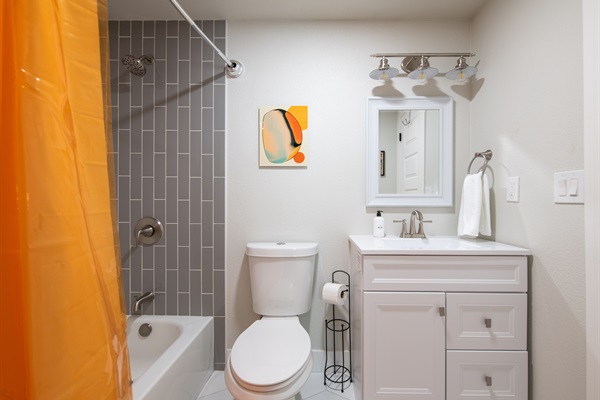 Full size bathroom with shower/bathtub next to dining room table area