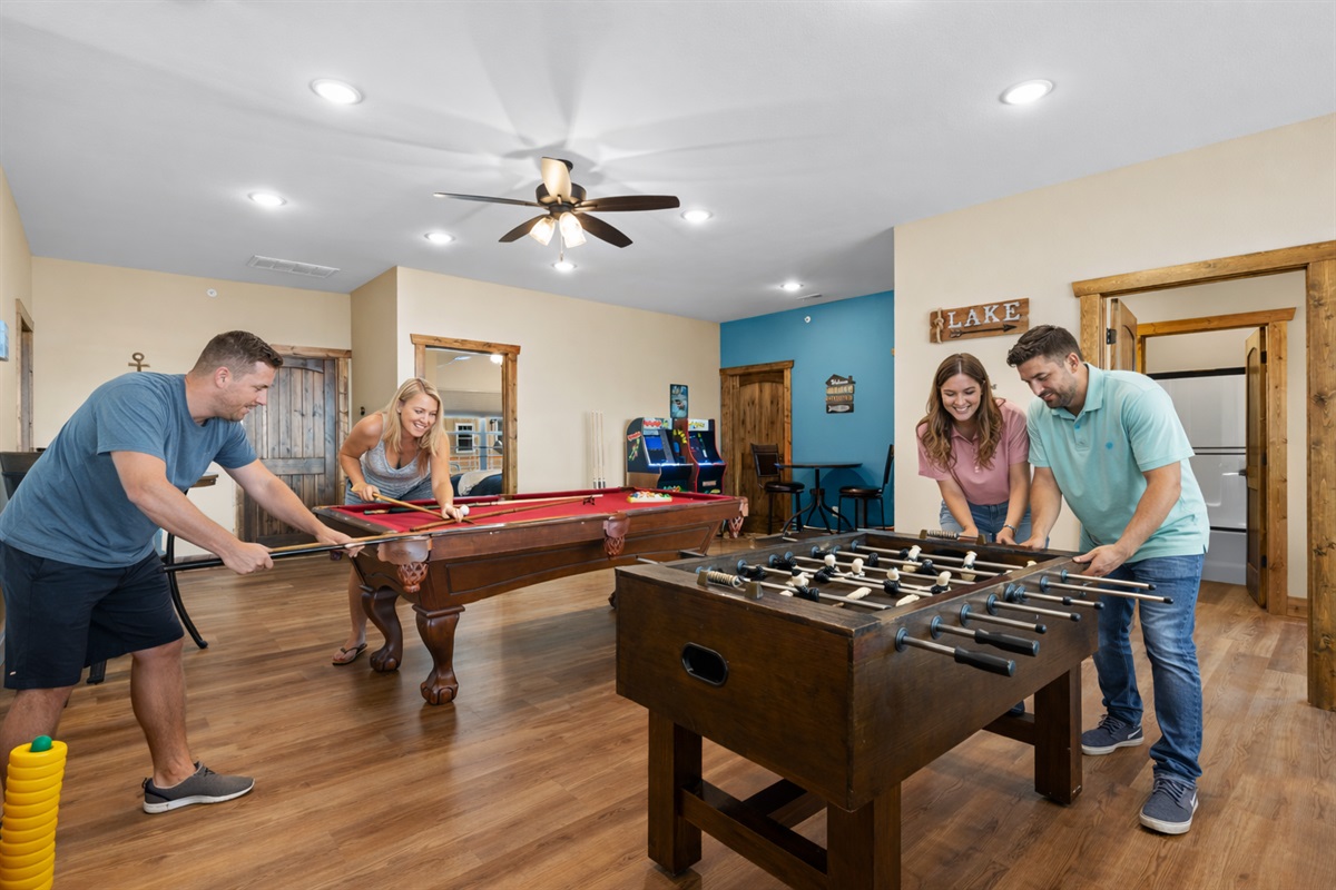 Fun-filled game room with pool table, foosball, and arcade games for friendly competition