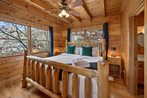 Main level king bedroom — private en-suite bath just through the door, nightstand lighting, and blackout curtains for a great night's sleep.