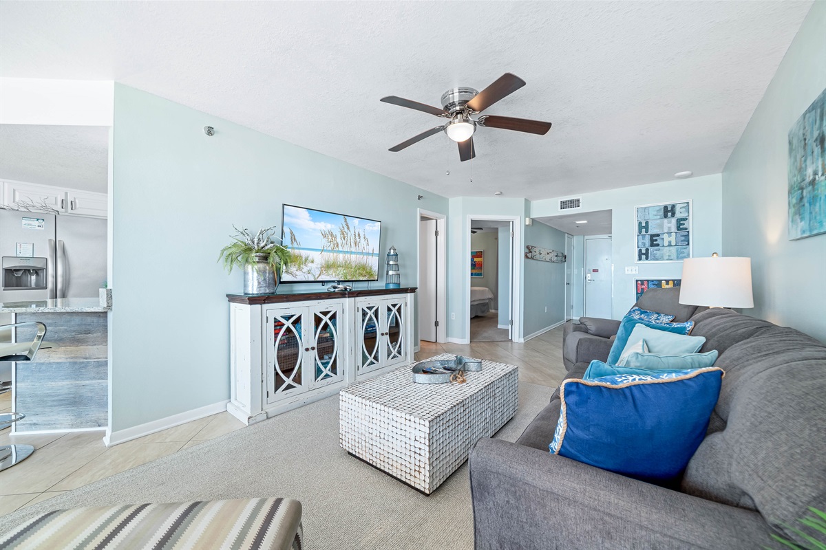Thoughtfully designed living area featuring a convenient sleeper sofa and balcony access. Perfect for family gatherings or quiet evenings by the sea.