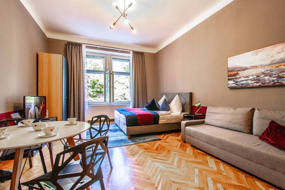 Comfortable bed, design chairs, and convertible sofa.