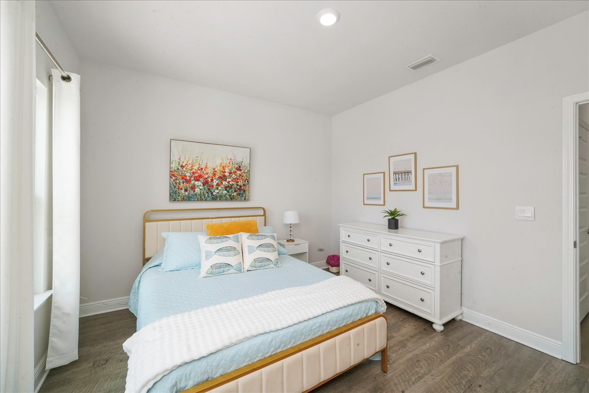Relax in this bright Queen Bedroom with soft linens, closet, luggage stand, and a nightstand for added convenience.