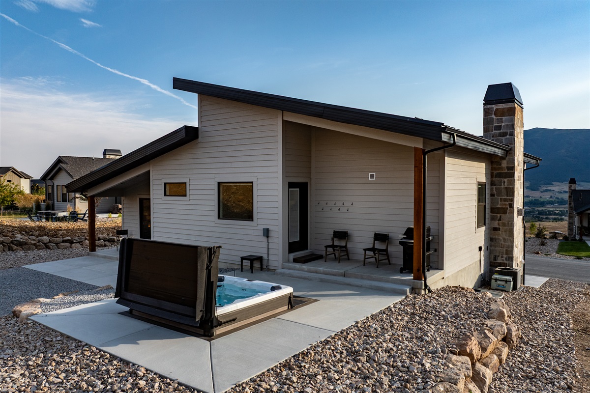 Lovely view of the back of the home, featuring the hot tub and inviting patio area.