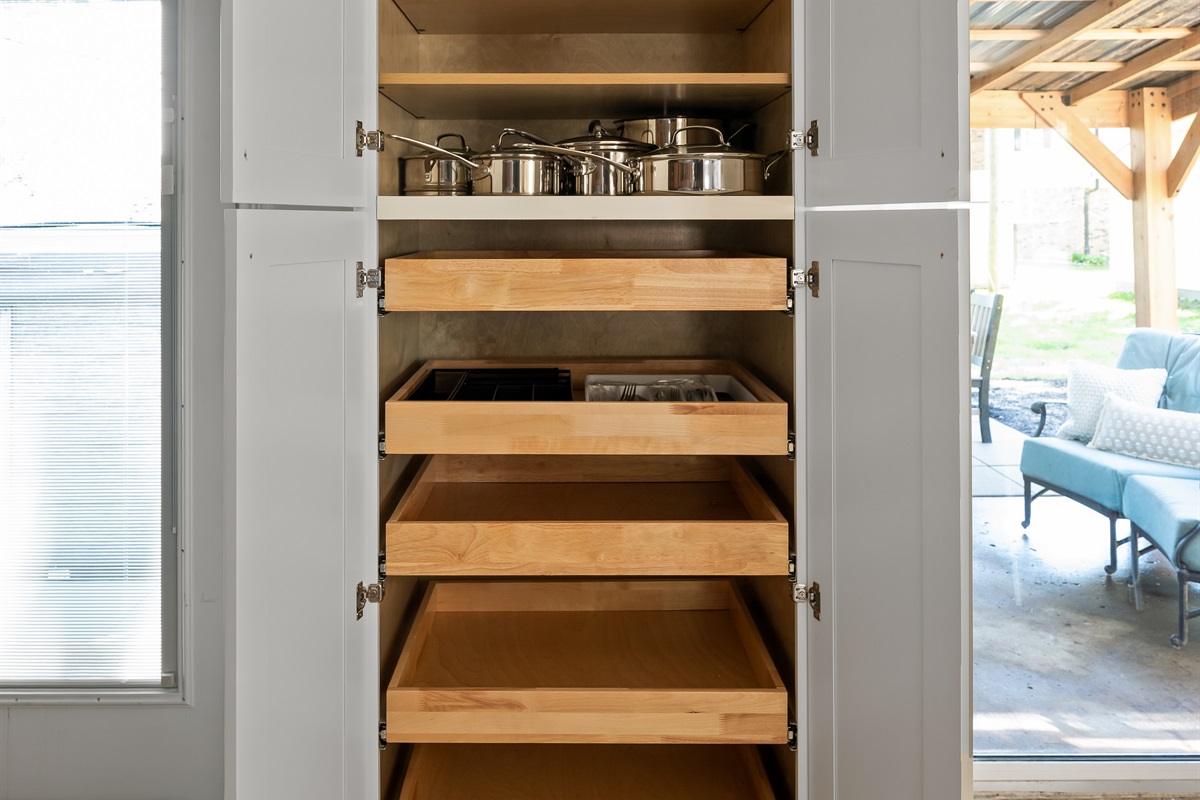 Built in cupboard area offers plenty of storage space and comes fully stocked with pots, pans, and kitchen essentials for your stay.