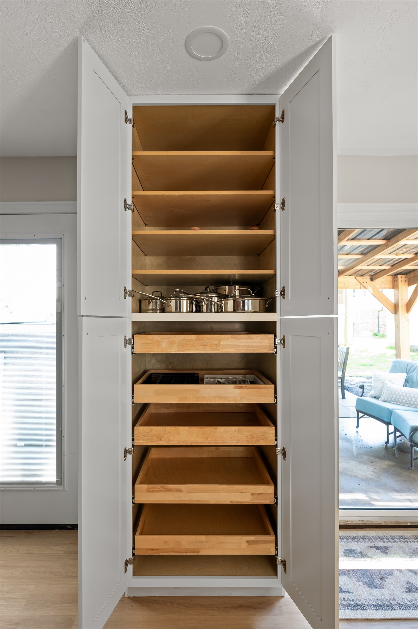 Built in cupboard area offers plenty of storage space and comes fully stocked with pots, pans, and kitchen essentials for your stay.