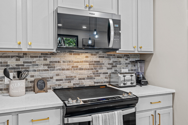 Equipped with stainless steel appliances, a large refrigerator, and a built -in microwave