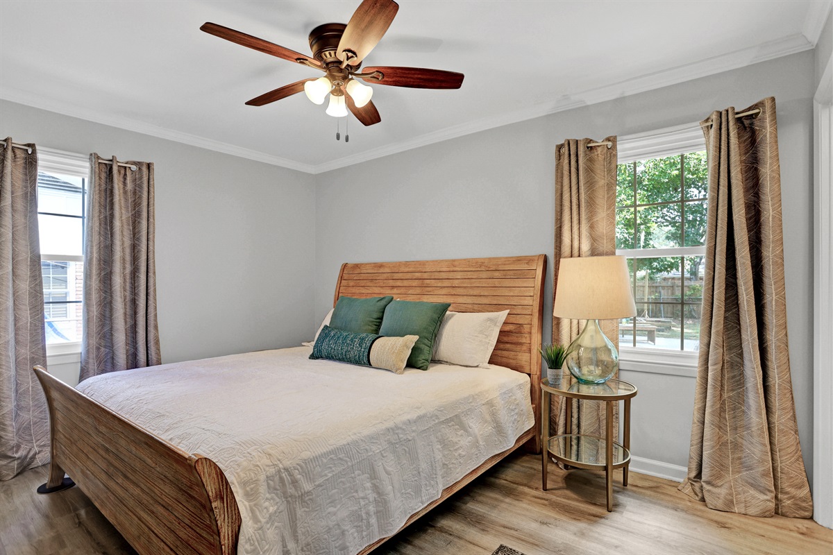 Rest easy in the serene primary bedroom featuring a plush king bed, cozy linens, and a peaceful retreat after a day of exploring.