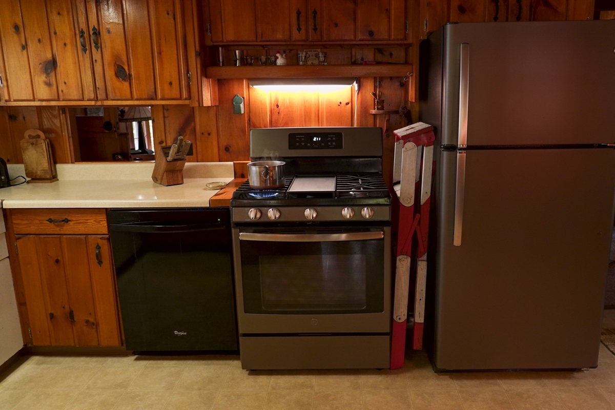 Kitchen has full sized fridge and freezer and gas stovetop and oven.