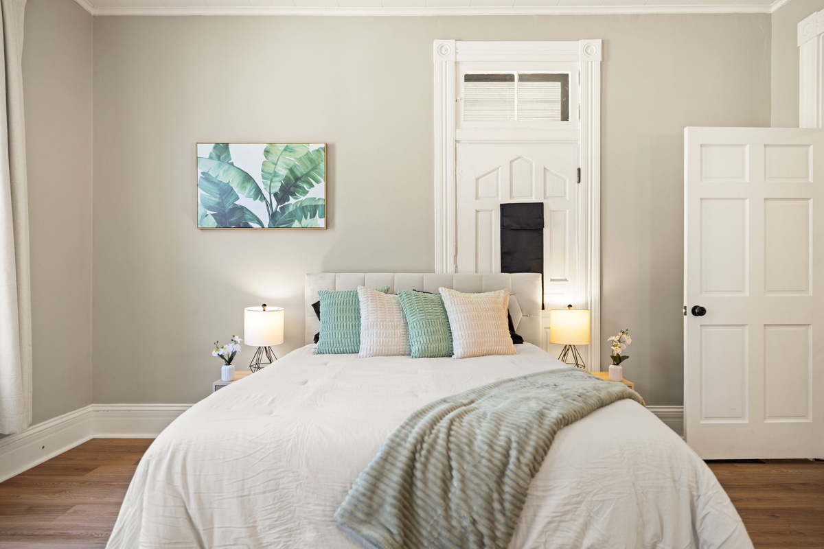 Cozy bedroom with soothing sage-green accents, designer wall art, and peaceful ambiance