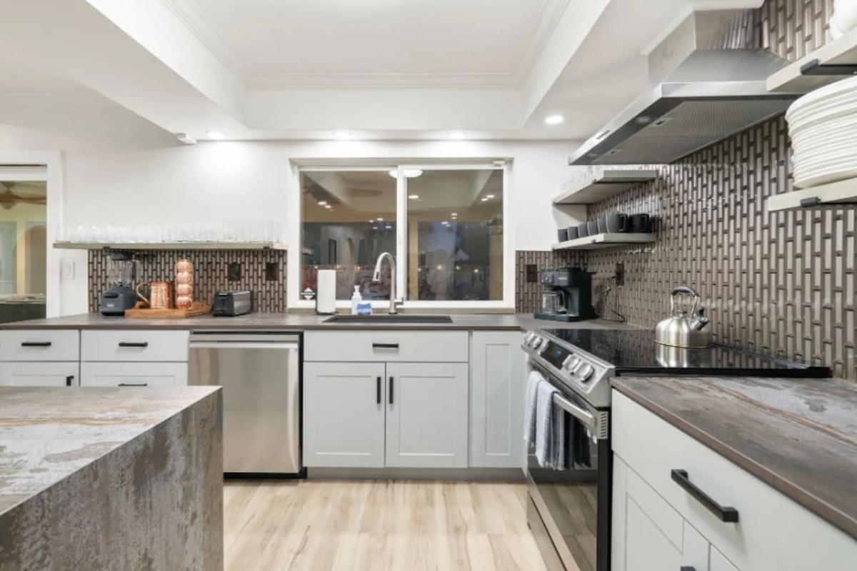 Textured tile backsplash and stainless appliances bring a modern edge to this fully equipped kitchen.
