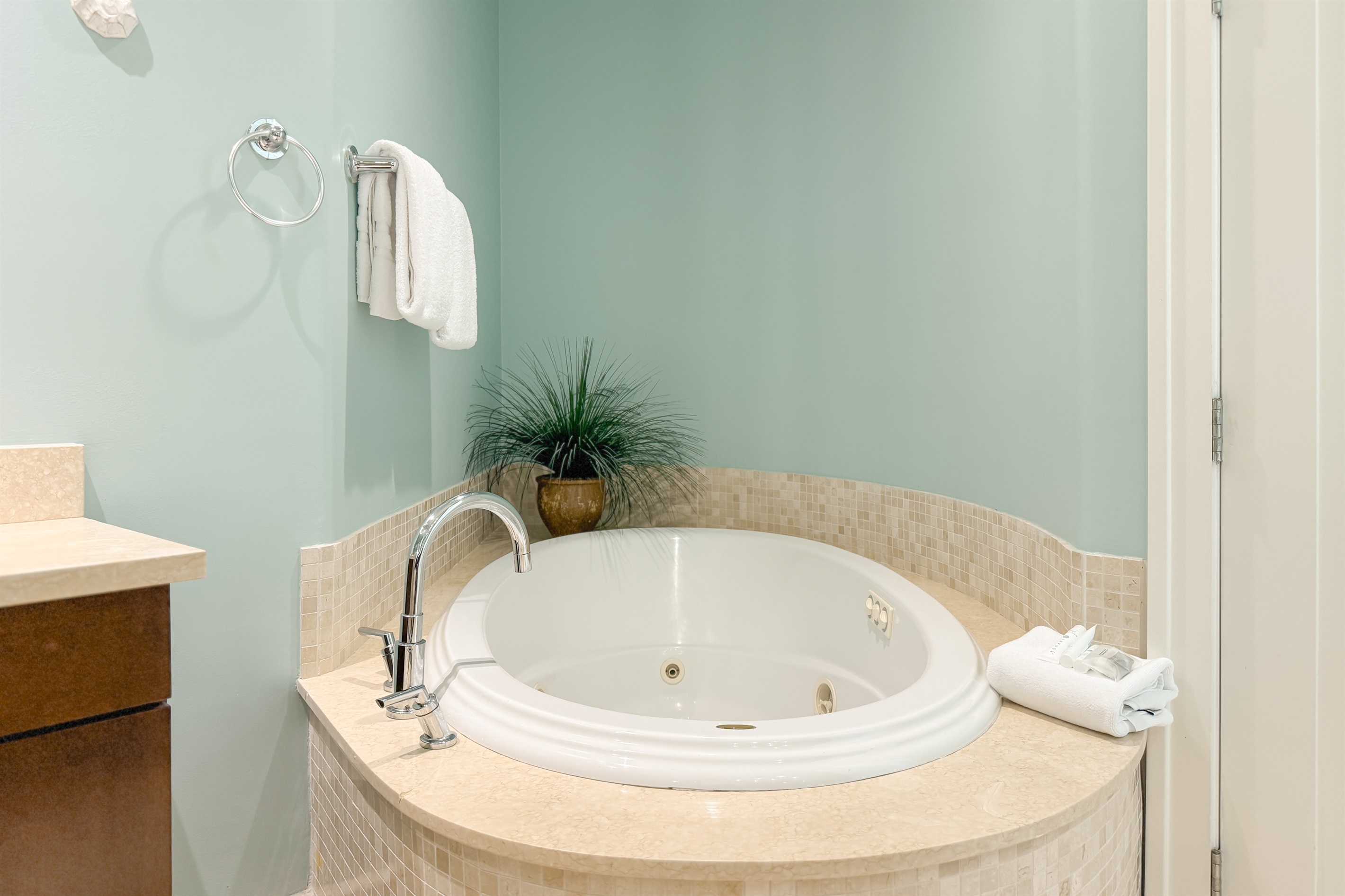 Primary bathroom showcasing a soaking tub, glass vessel sink vanity, and seamless transition to the master bedroom. A perfect blend of luxury and convenience.