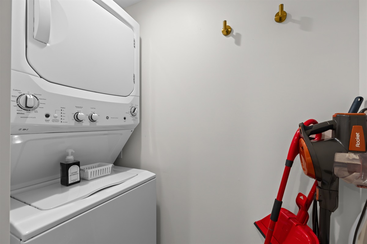 Convenient in-unit washer and dryer with nearby wall hooks and space for cleaning essentials—making longer stays easy and comfortable.