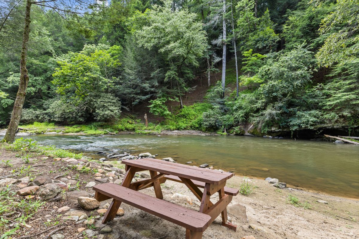 The property's sandy shoreline is perfect for relaxing, skipping rocks, or enjoying a riverside picnic.