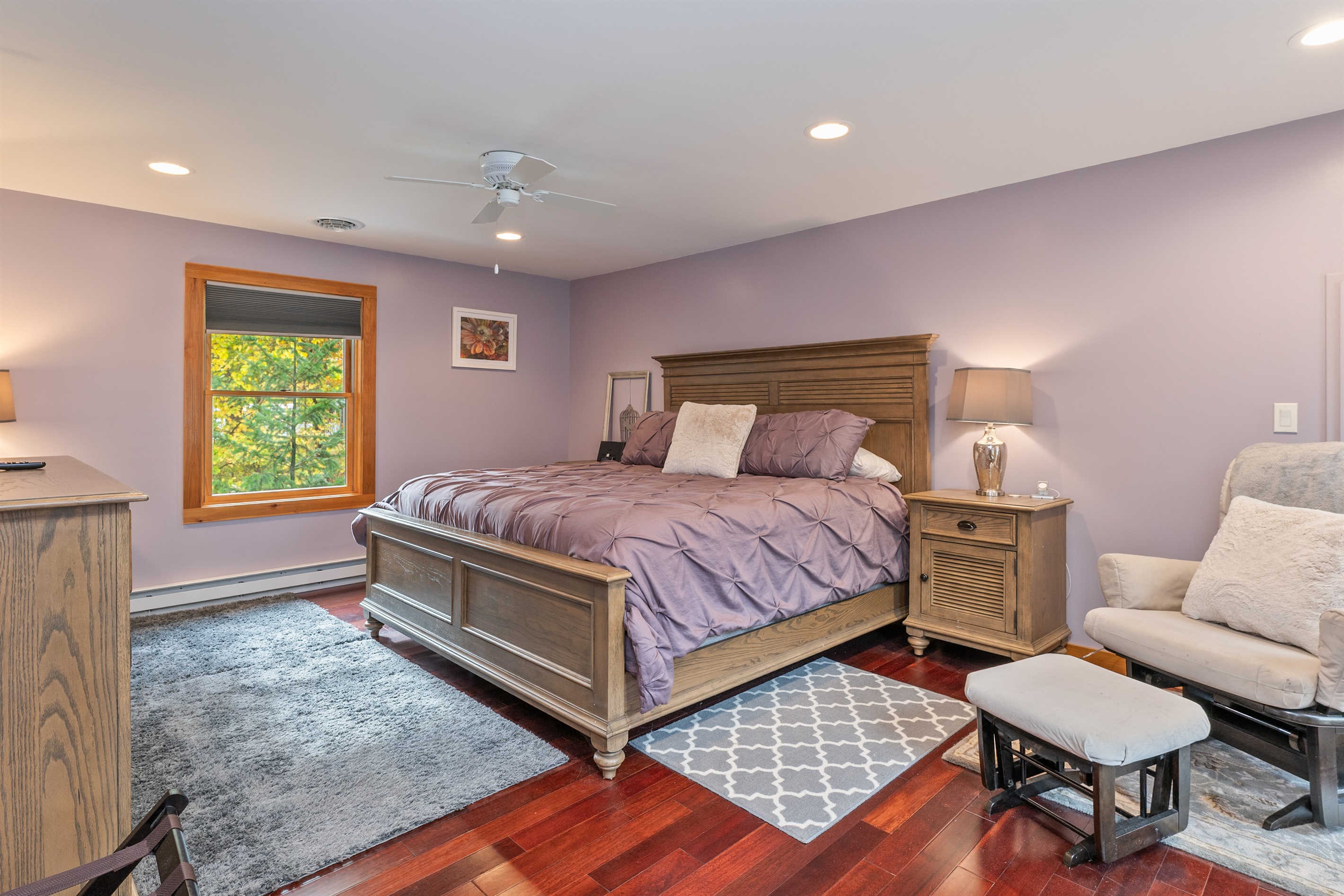 Spacious primary suite with plush bedding, scenic window views, and calming tones for ultimate rest and relaxation.