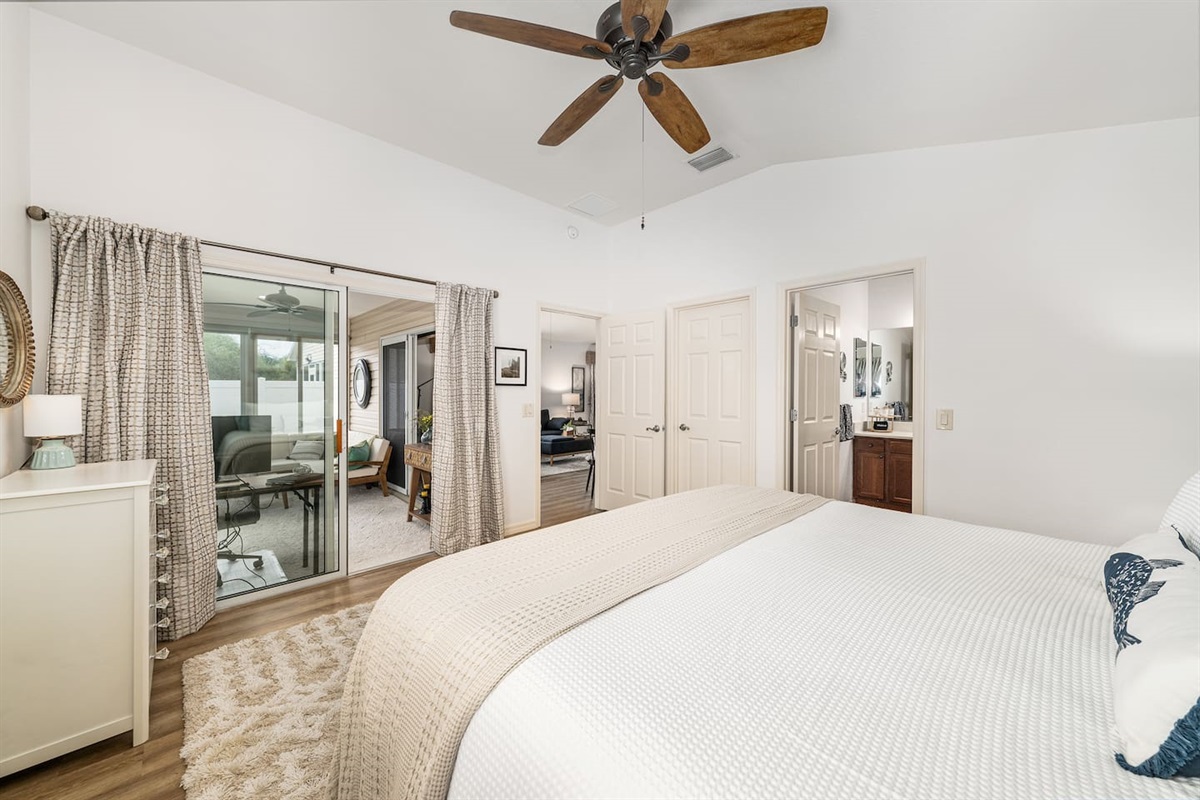 The master bedroom features sliding doors to the sunroom, a walk-in closet, ensuite bathroom, and a comfortable king bed.