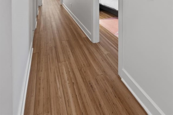 Elegant wooden flooring leads you to cozy bedrooms—an inviting and spacious hallway perfect for a comfortable stay