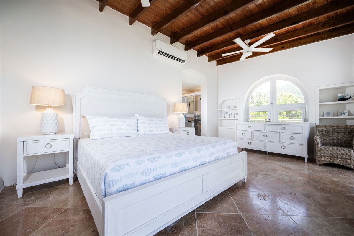 Main Floor Guest Bedroom: Bright bedroom with calming ocean tones and inviting atmosphere, features a plush king bed.