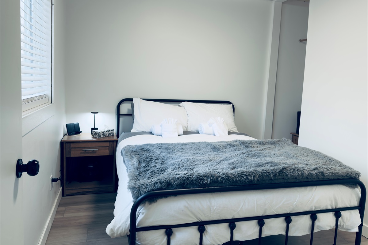 Queen bedroom with soft bedding and natural light