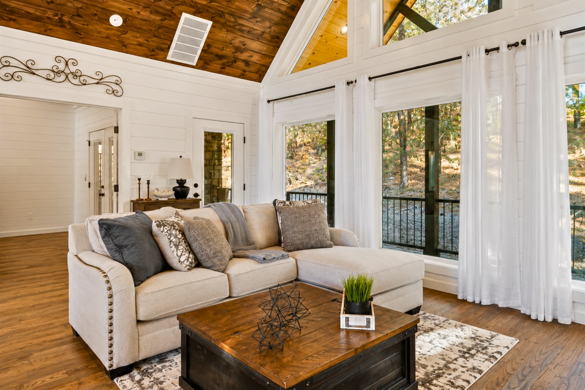 Curl up on the comfortable sofa with peaceful wooded views surrounding you and natural light pouring through the floor-to-ceiling windows.