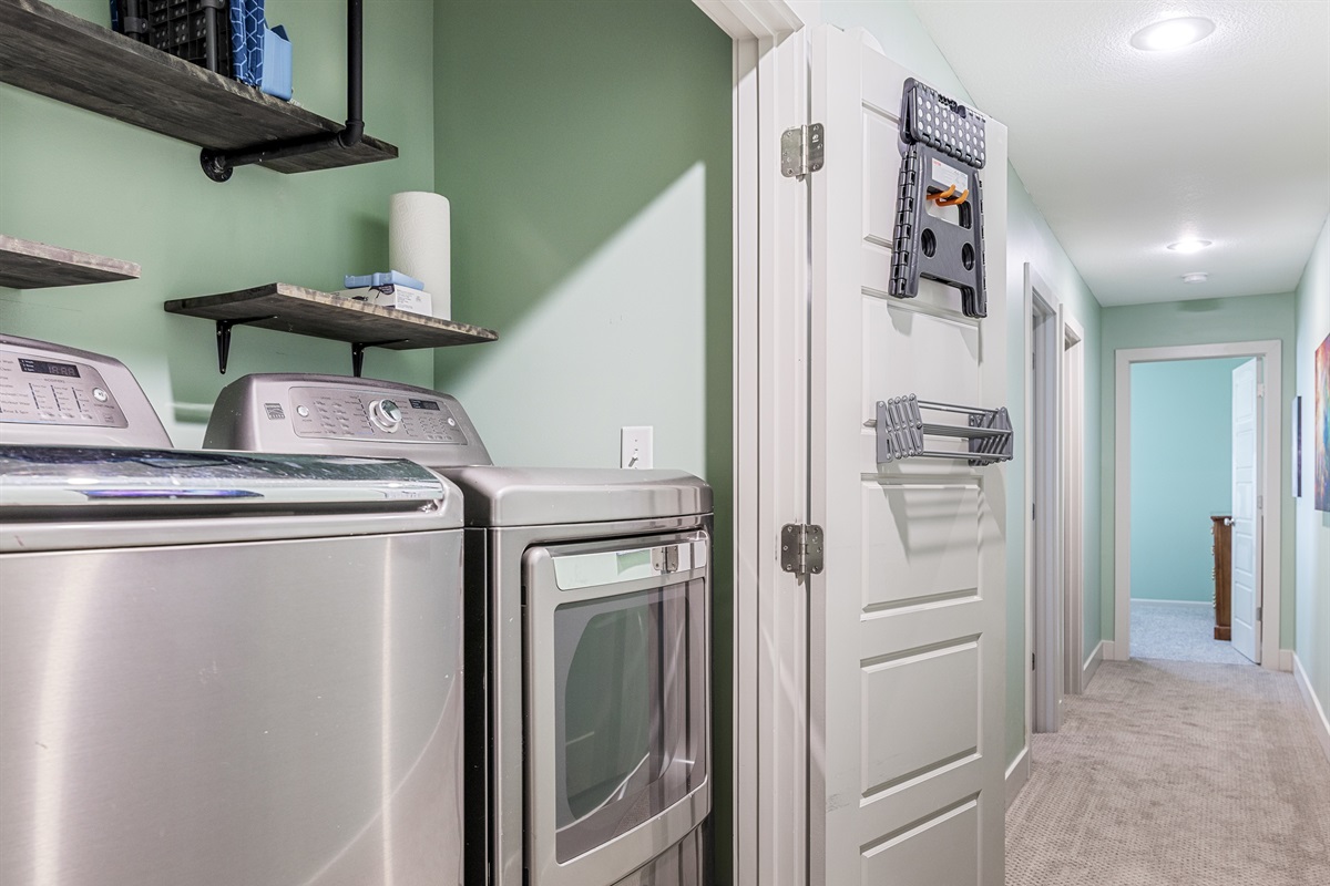 Fully equipped laundry area with a full-size washer and dryer, ironing board, hanging rack, detergent, bleach, and stain remover. Additional cleaning supplies are provided for added convenience during your stay.
