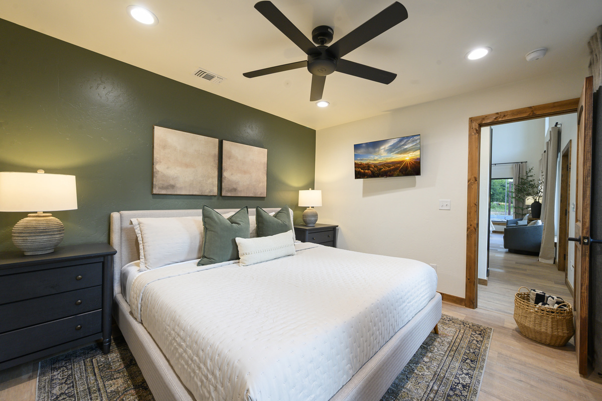A restful king bedroom with rich olive tones, crisp linens, thoughtfully styled to feel polished yet comfortable after a full day of cabin fun.
