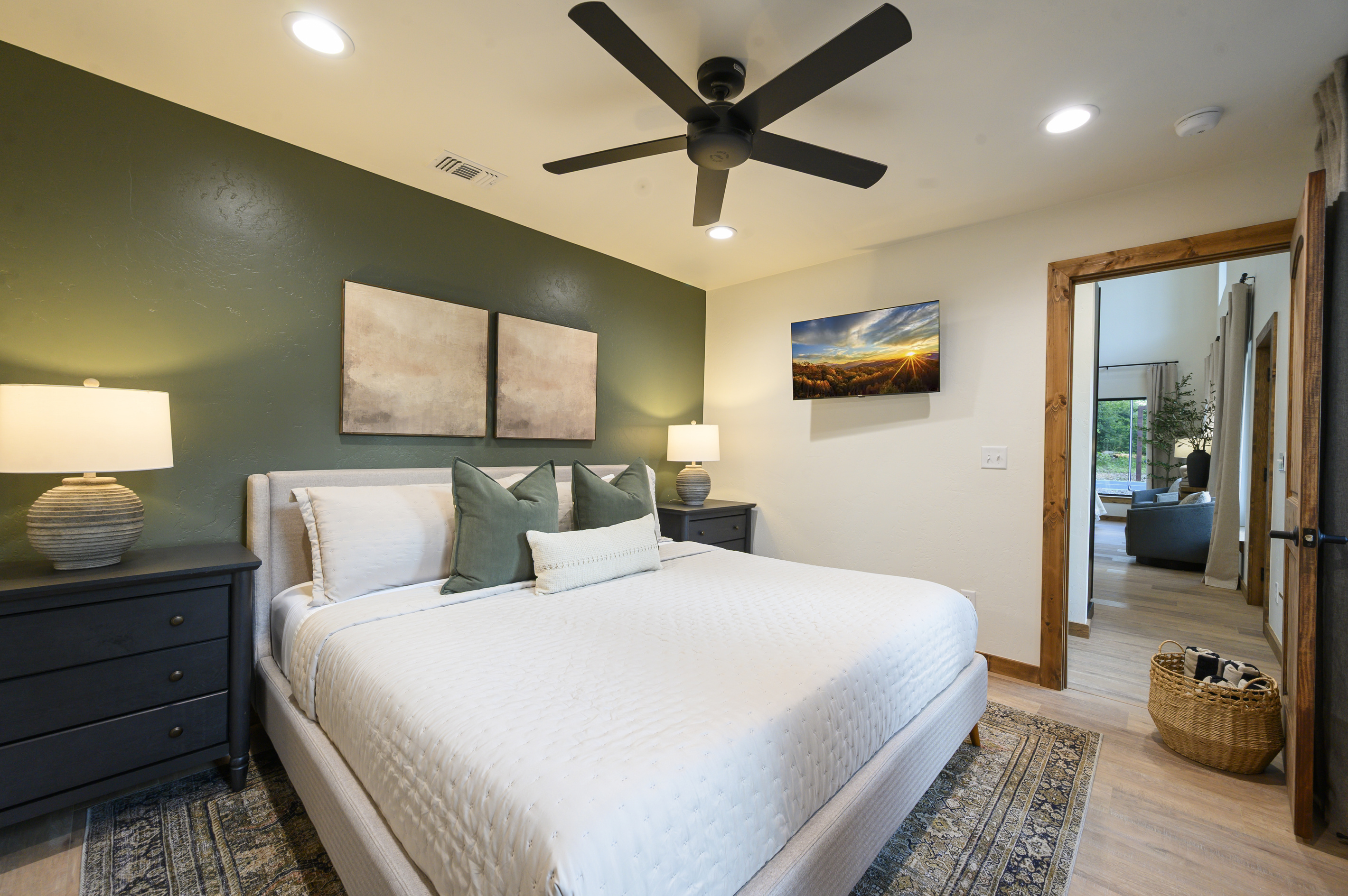 A restful king bedroom with rich olive tones, crisp linens, thoughtfully styled to feel polished yet comfortable after a full day of cabin fun.
