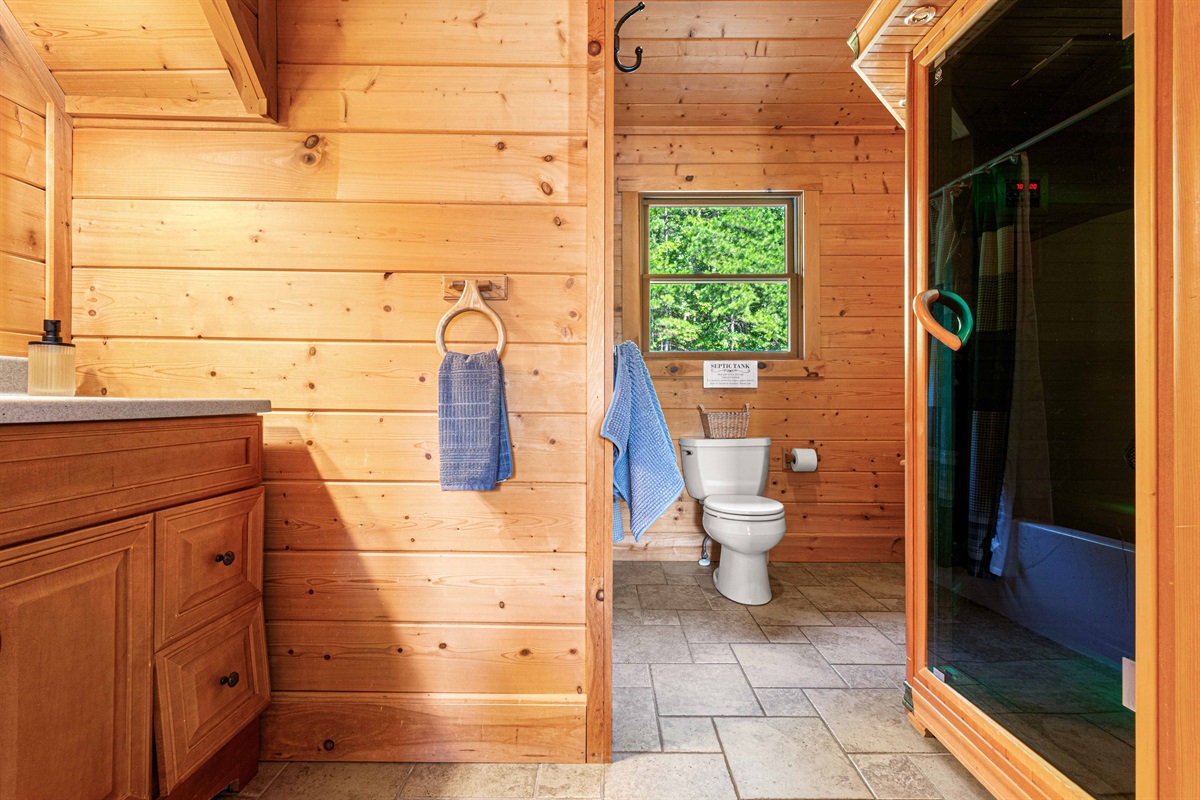 Upstairs Bathroom 2: Relax in a bright, wood-paneled retreat with serene views and modern amenities!