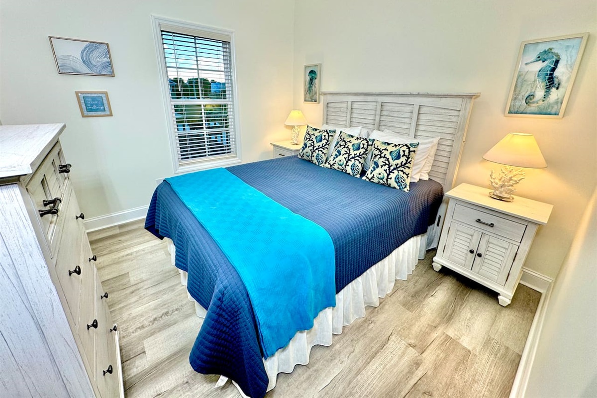 Queen bed with a smart TV and blackout curtains.