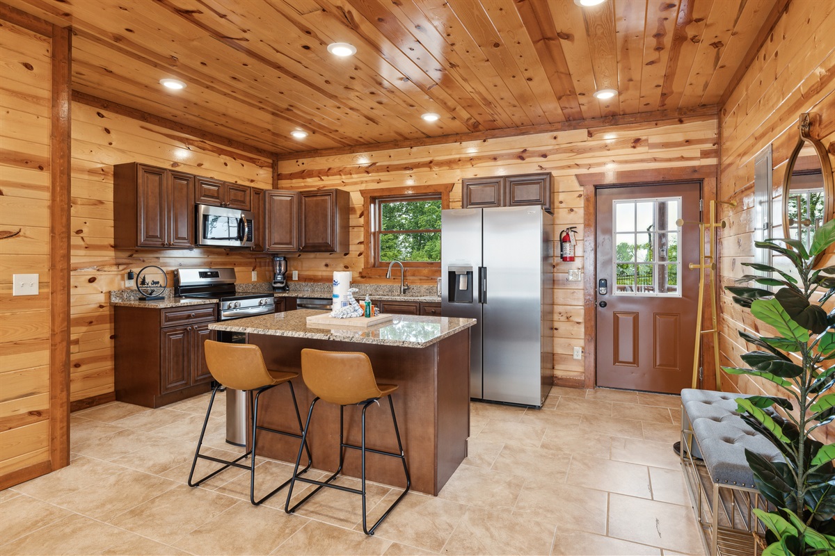 Fully equipped chef’s kitchen with granite countertops and bar seating.