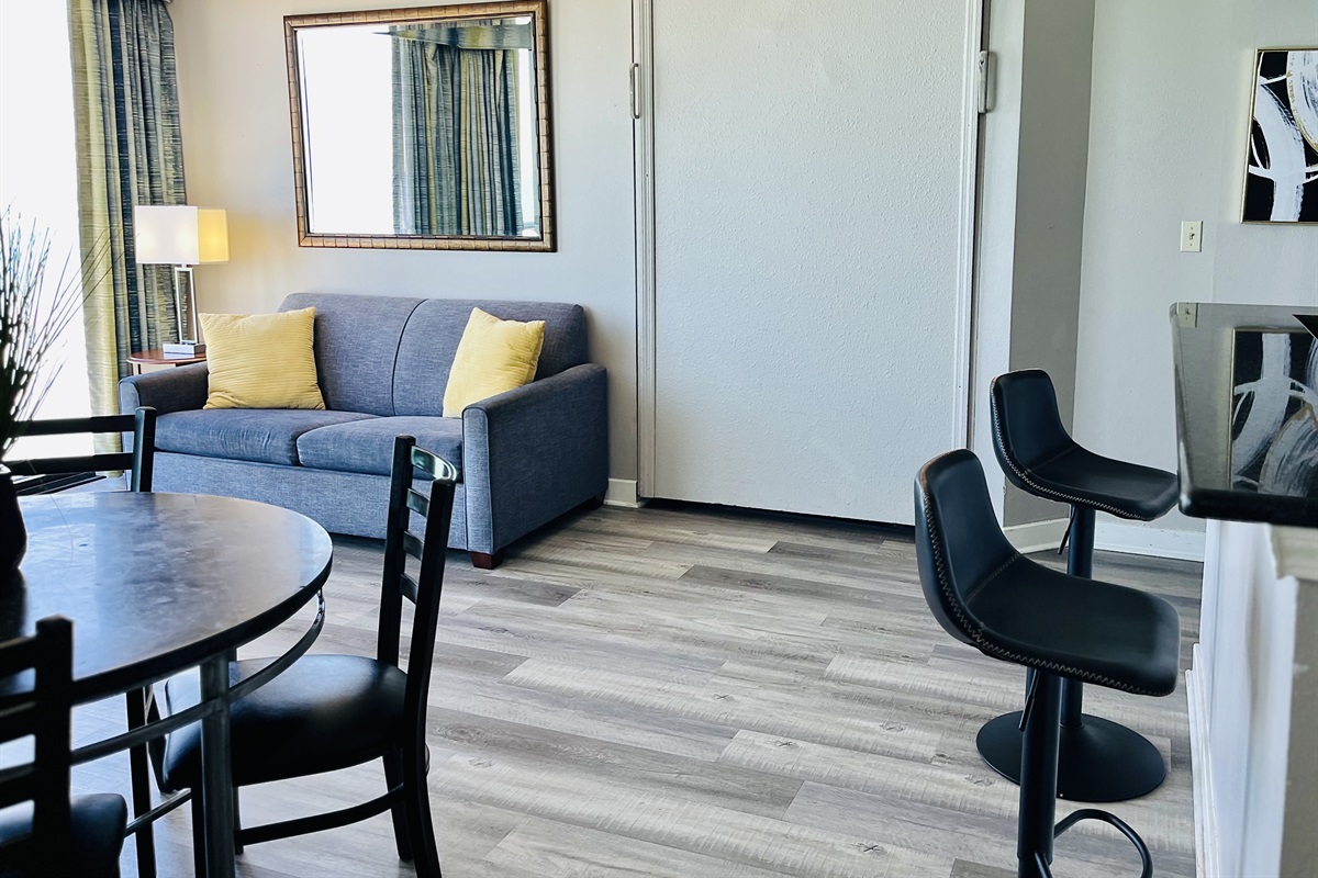 Experience open-air comfort in the living area, where the sliding glass doors bring in the coastal breeze, creating a refreshing and inviting space.