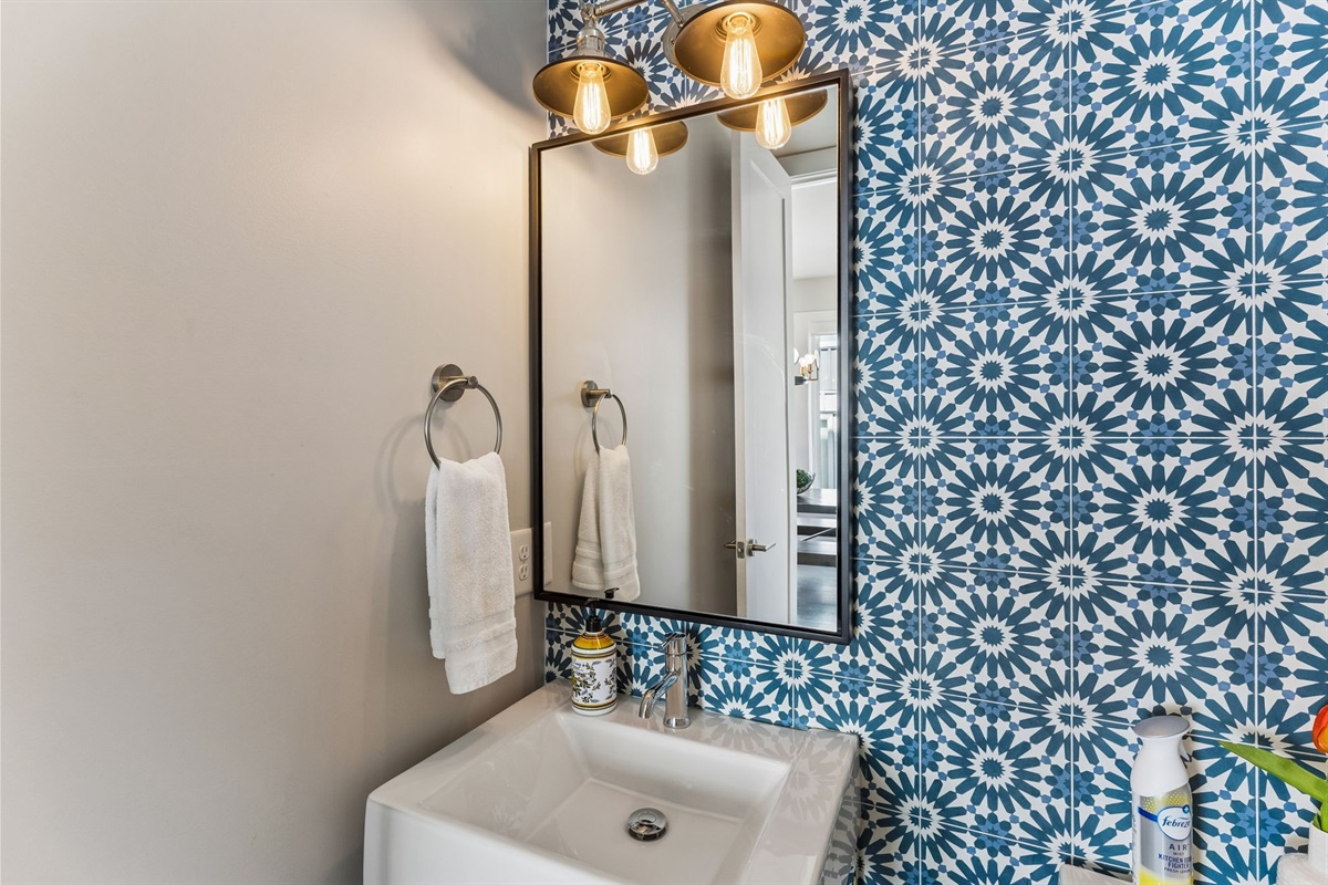 Step into the powder room and you'll do a double take &mdash; floor-to-ceiling teal geometric tile and a Nashville neon sign that earns its Instagram moment.